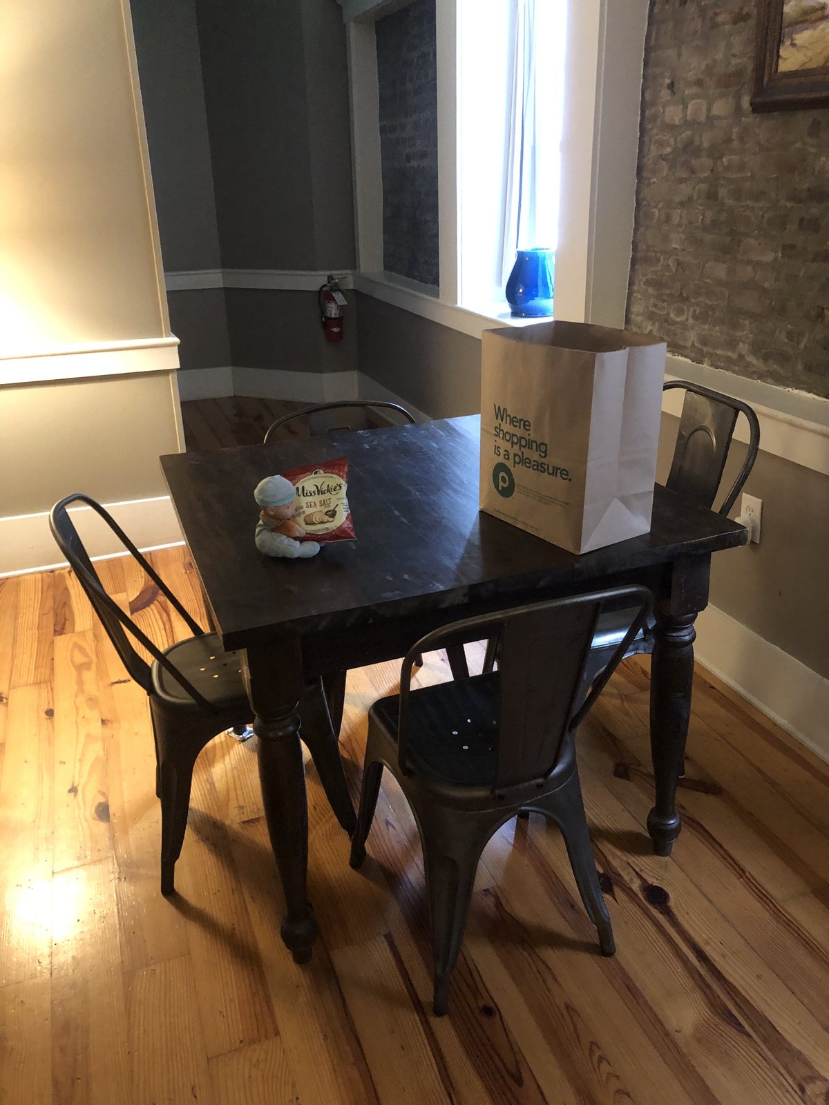 9:02am, the apartment table. Lucy, seated, keeping the chips company. She spent most days waiting for us right here.
