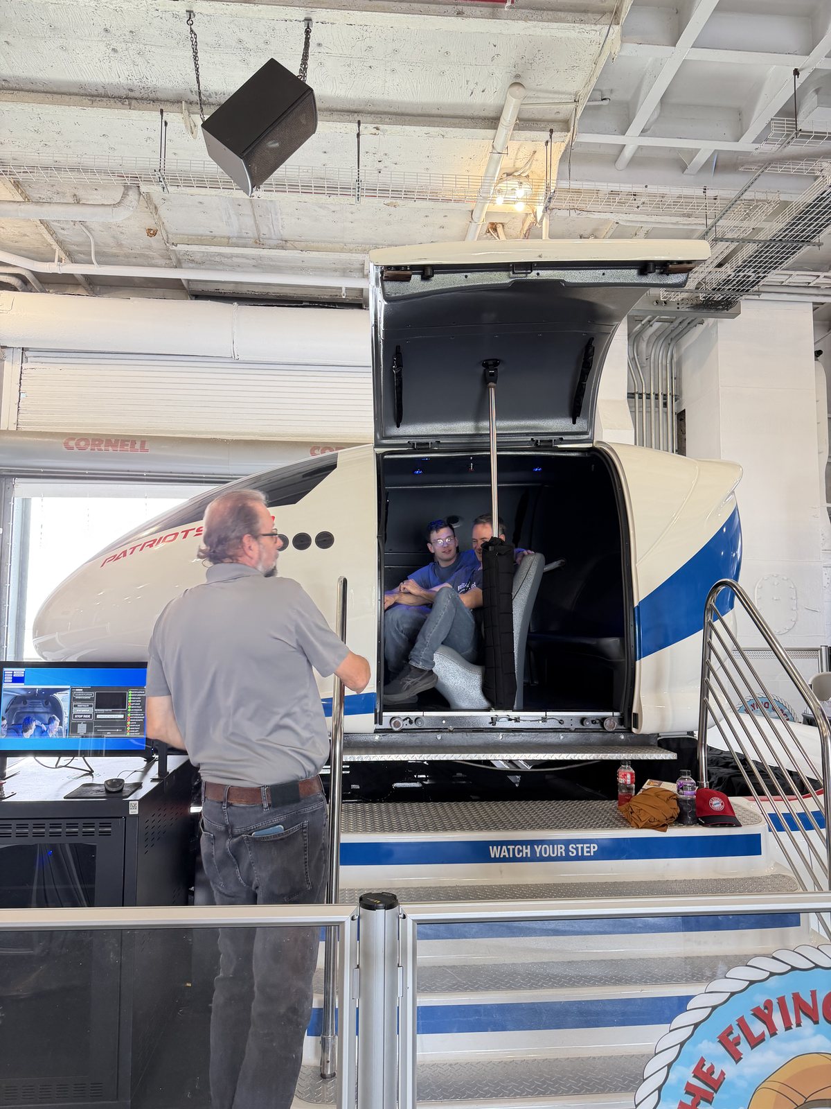 The flight simulator: Dad and the boys strapped in, Mommy sensibly on the outside.