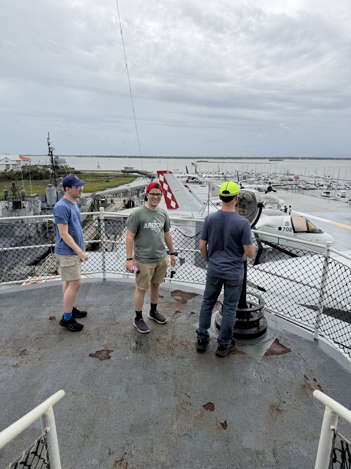 Top of the island — boys and Dad, with the whole flight deck, the Laffey and the marsh below.